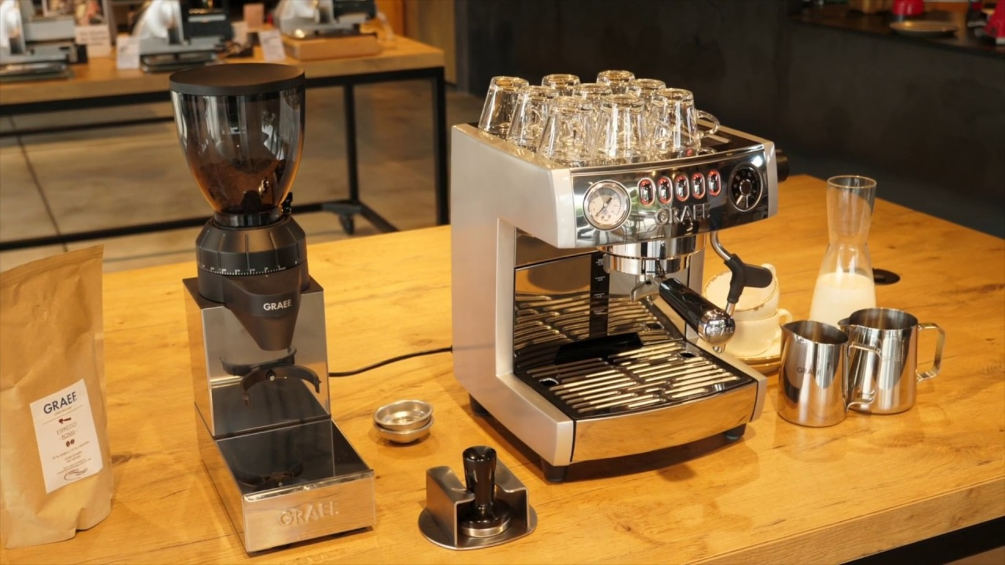 Kaffeemaschine und Zubehör auf einem Holztisch, bereit für die Zubereitung von Kaffee.