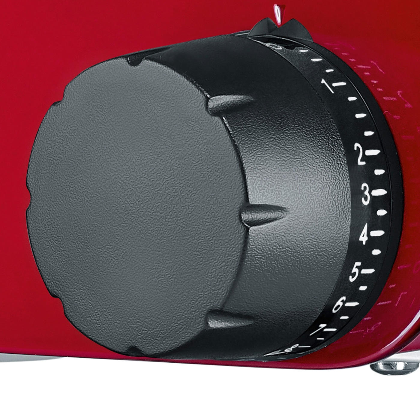 Close-up of a red appliance with a black dial and numbered settings.