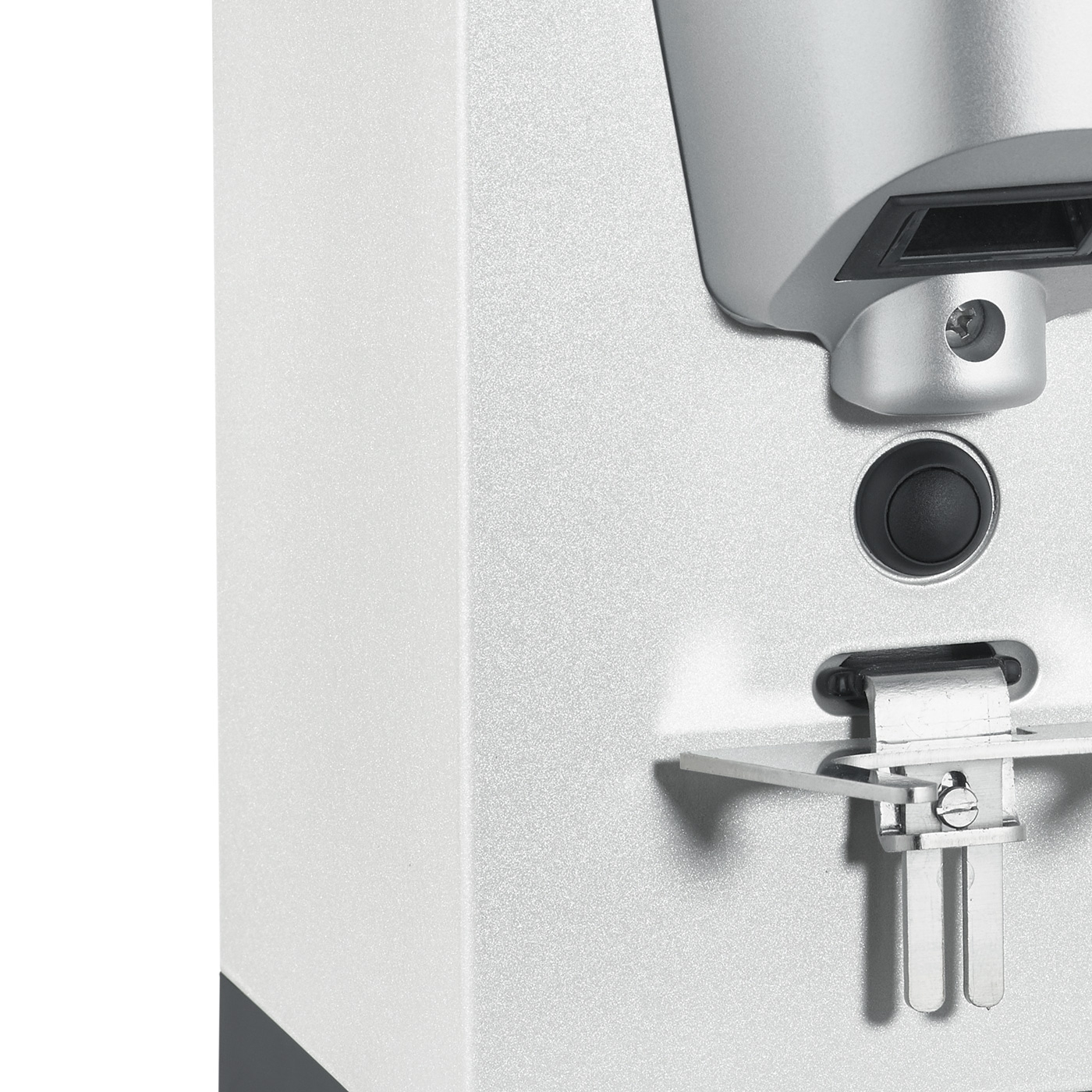 Close-up of a silver appliance with a button and metal components.