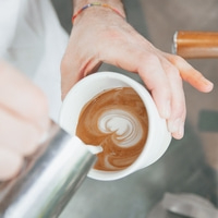 Latte art: Barista pouring milk into a cup to create a heart design.
