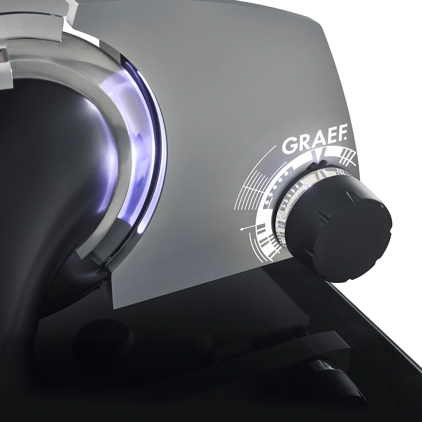 Graef slicer detail, knob, gray surface, blue light, brand name, close-up, machine