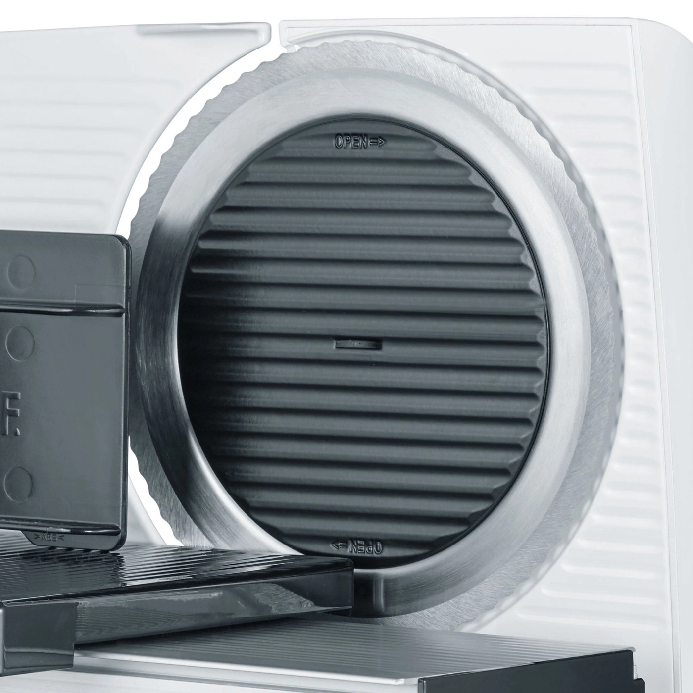 Close-up of a food slicer, focusing on the blade and operational controls.