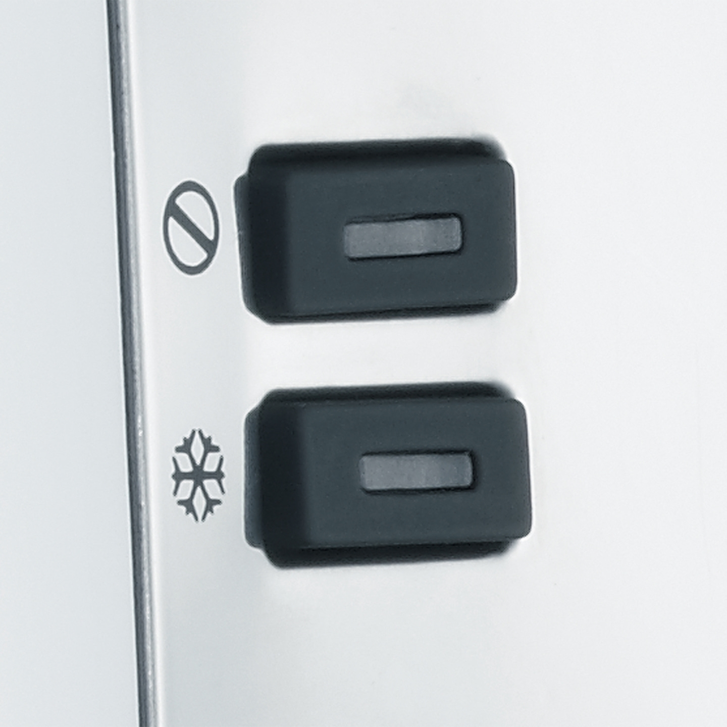 Zwei schwarze Knöpfe mit Symbolen, die auf einer weißen Oberfläche angebracht sind.