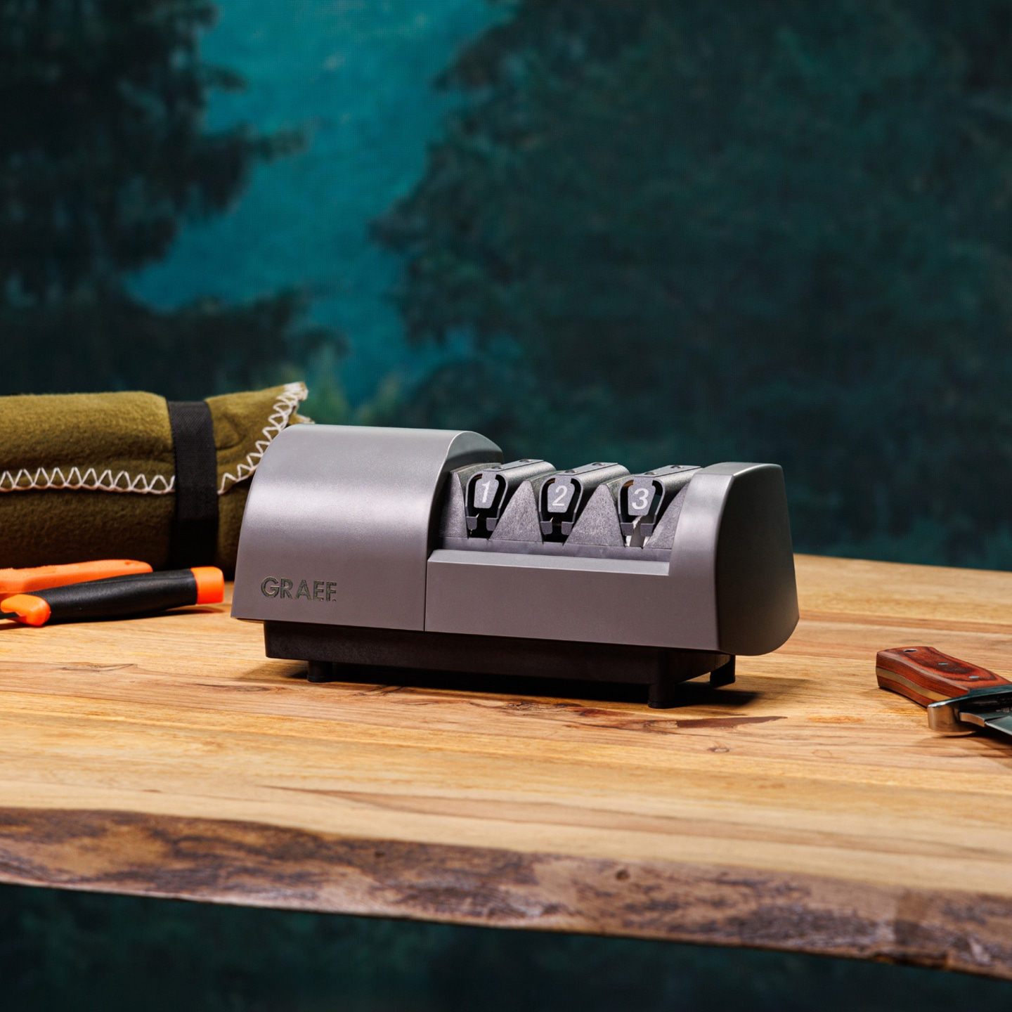 Graef Messerschärfer auf Holz mit Messer und Werkzeug im Hintergrund