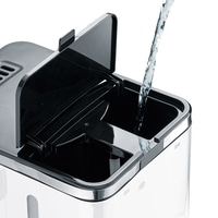 Wasser wird in einen Behälter gegossen, der einen Deckel hat.