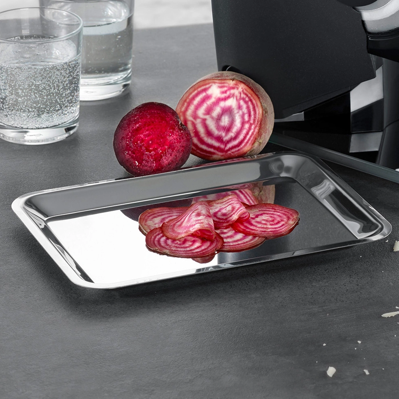 Beets on a metallic tray next to glasses of water