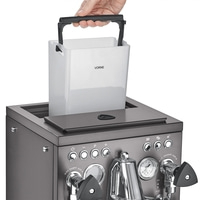 Person hebt Wassertank aus einer Kaffeemaschine heraus, Nahaufnahme.