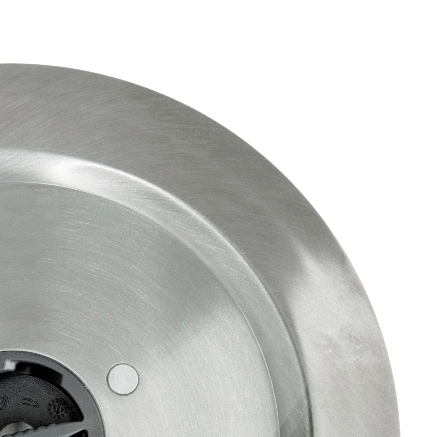 Close-up of a silver metal plate with a hole and a black part, shiny surface.