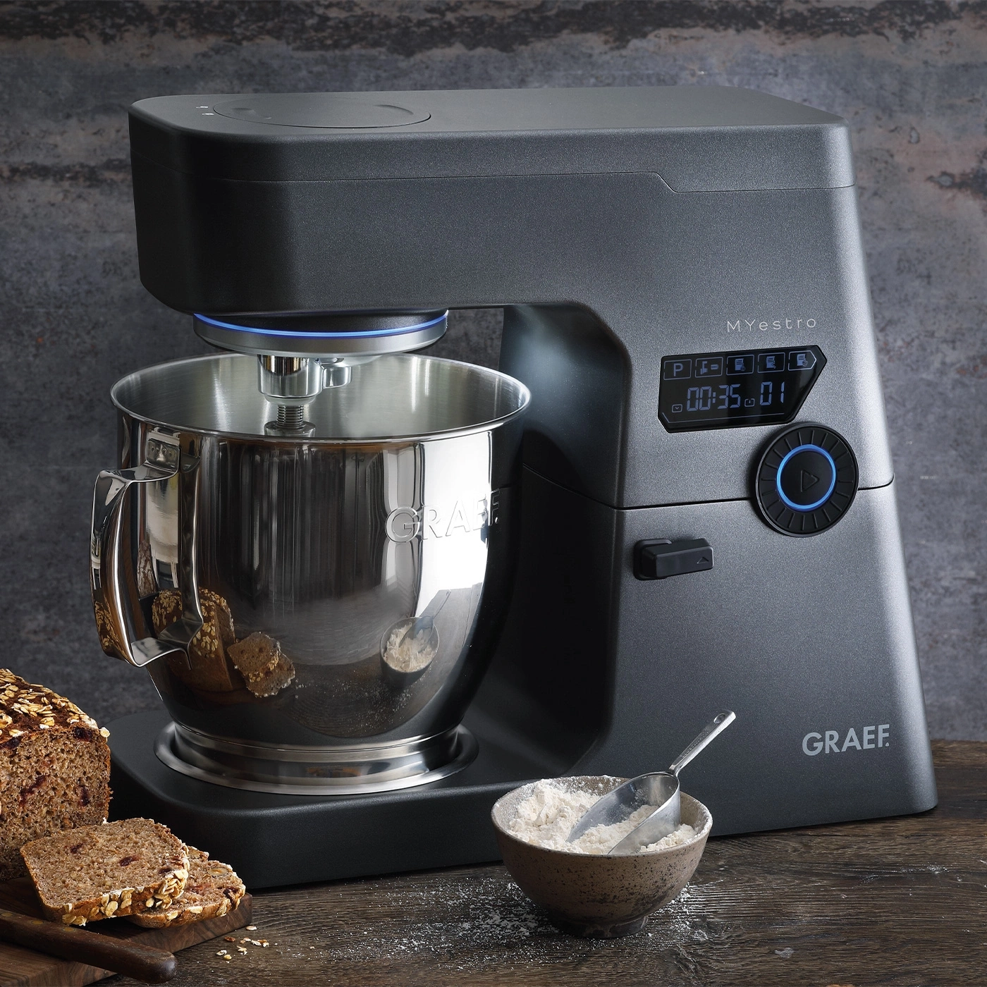 Küchenmaschine mit Brot und Mehl auf einem Holztisch