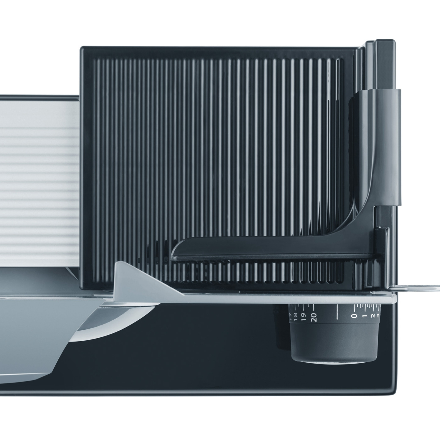 Close-up of an electric food slicer with adjustable carriage and scale.