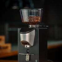 Kaffeemühle mit Bohnen im Behälter und Mahlgradregler