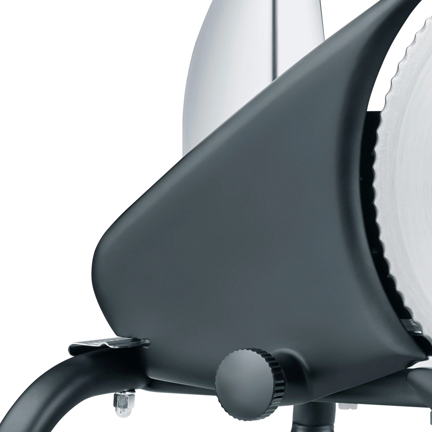 Close-up of a black meat slicer with a serrated blade and adjustment knobs