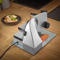 Graef Allesschneider mit Tomatenscheiben und Brot auf Holzoberfläche