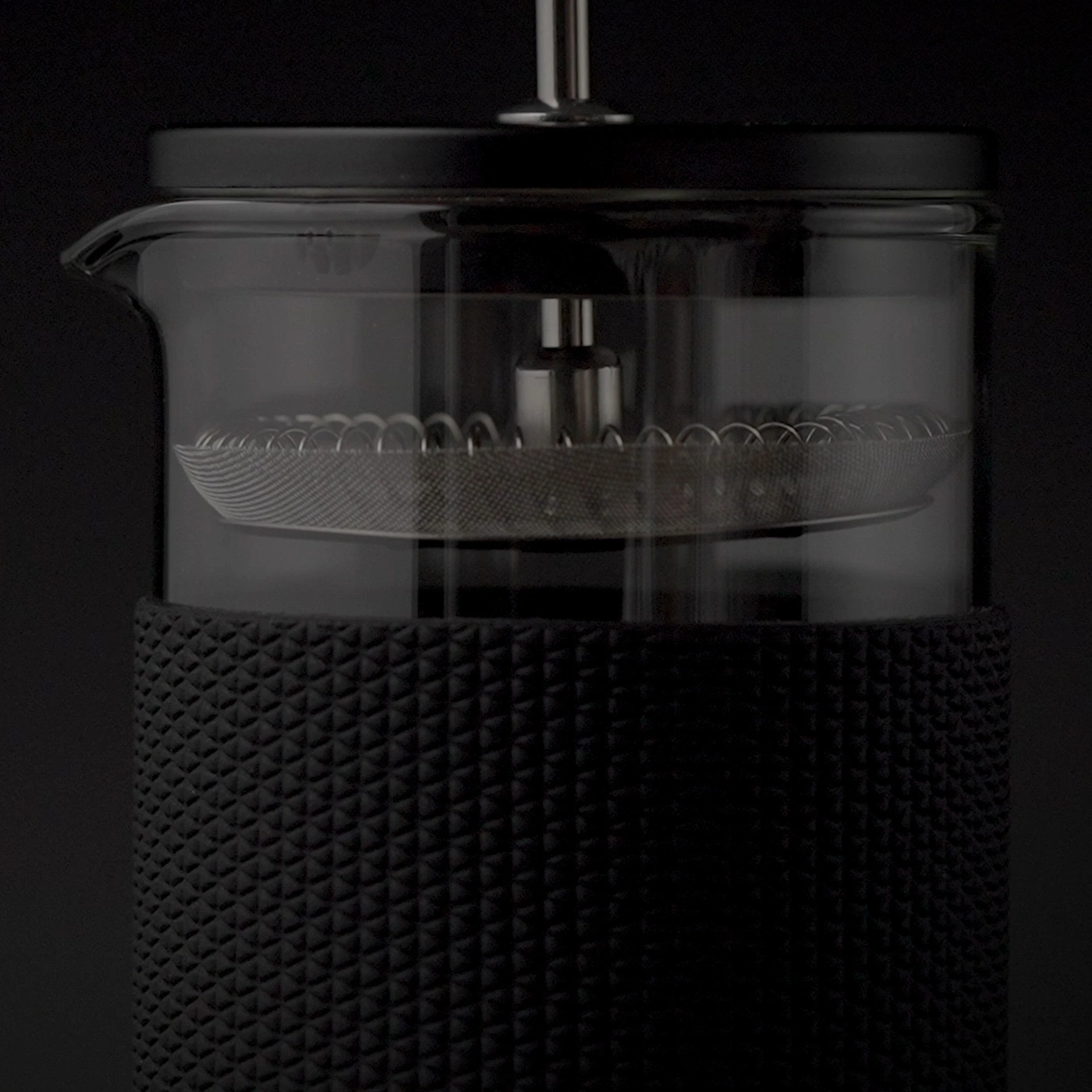 Nahaufnahme einer schwarzen French Press mit Glasbehälter und Metallfilter.