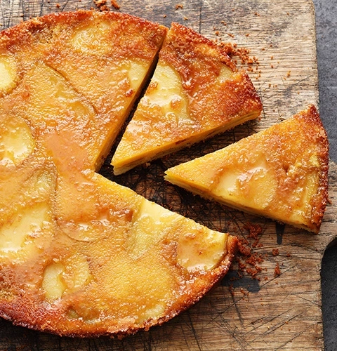 Ein köstlicher Apfelkuchen, der auf einem Holzbrett serviert wird, ist angeschnitten.