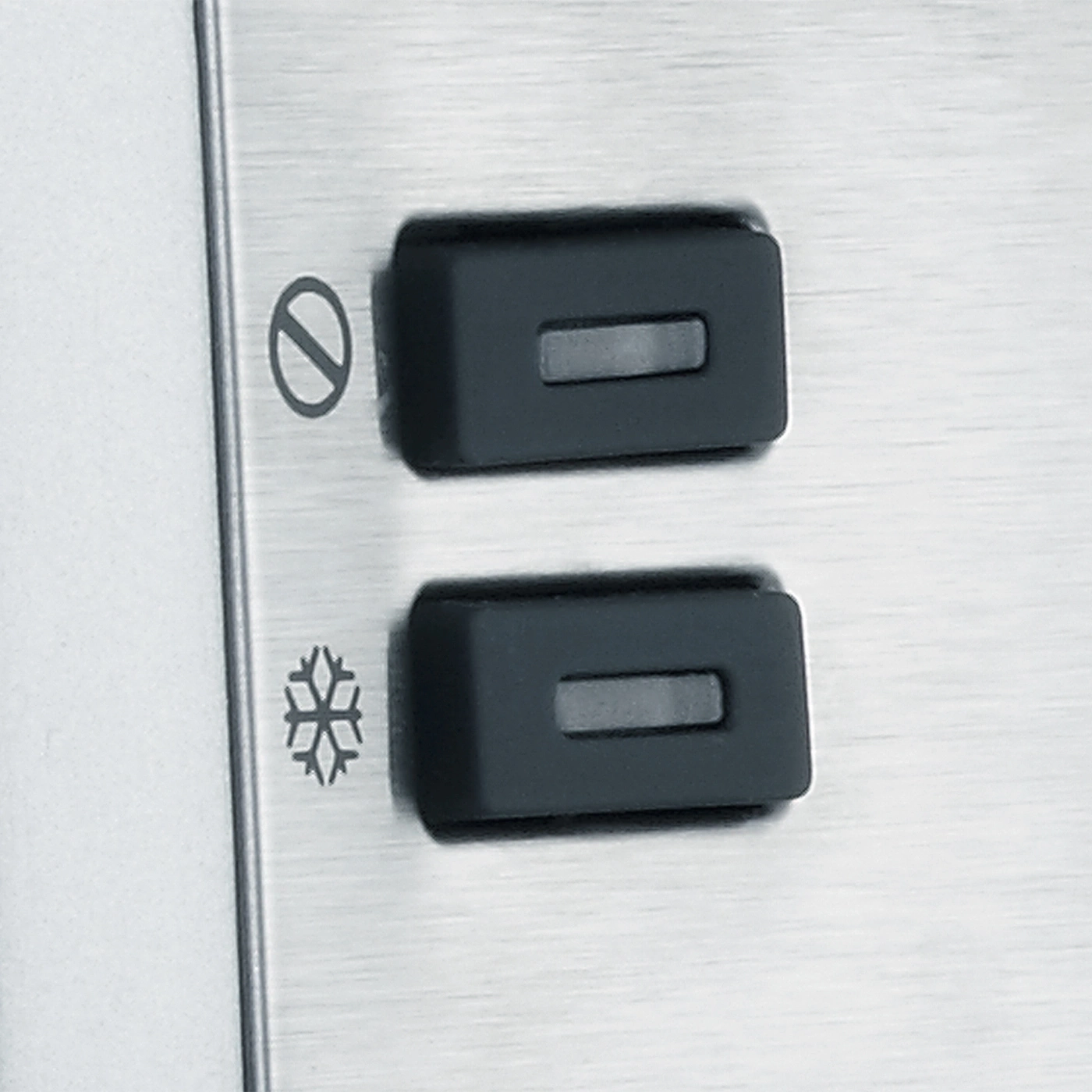 Two black buttons with symbols on a metallic surface.