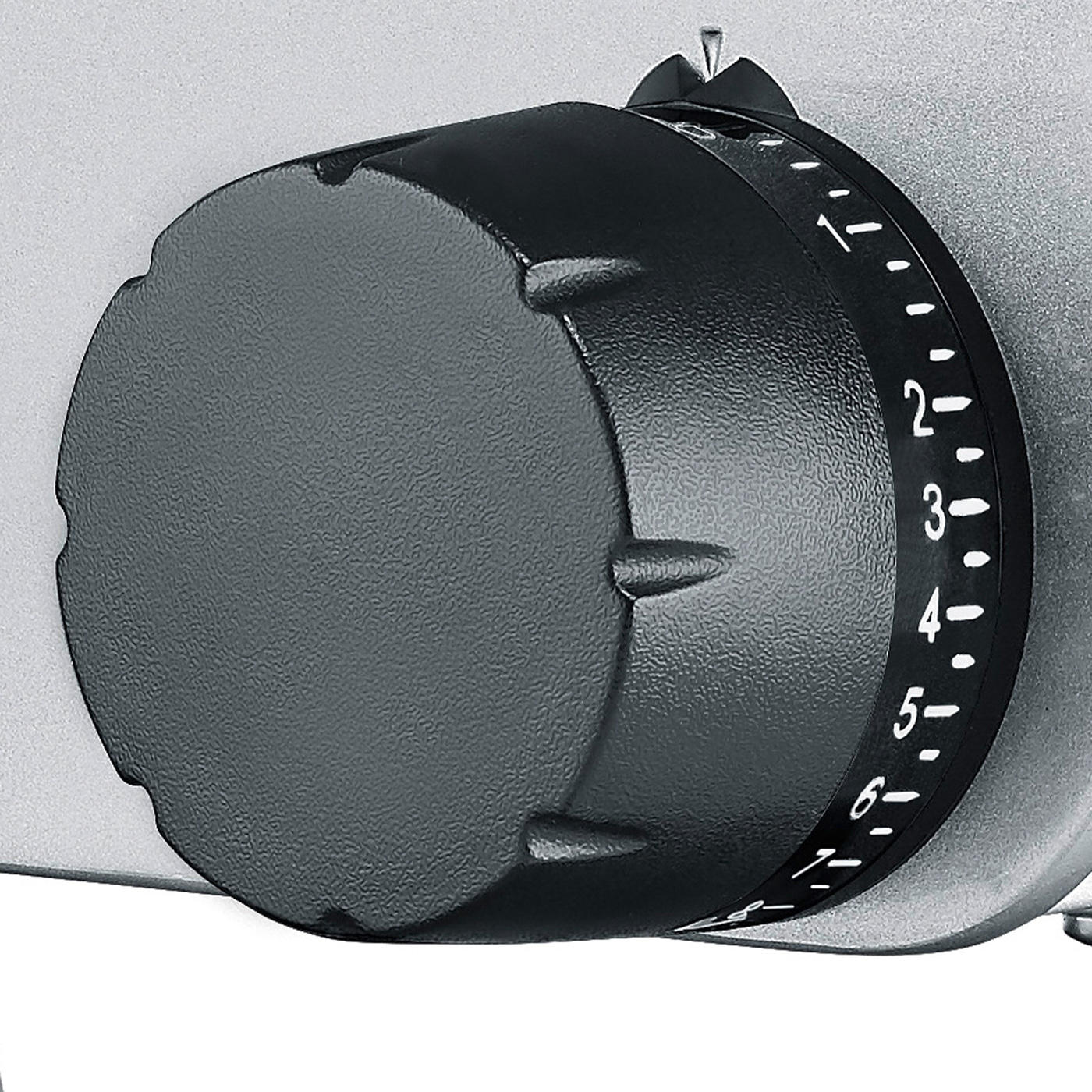 Schwarzer Drehknopf mit Zahlen auf silbernem Hintergrund, Nahaufnahme.