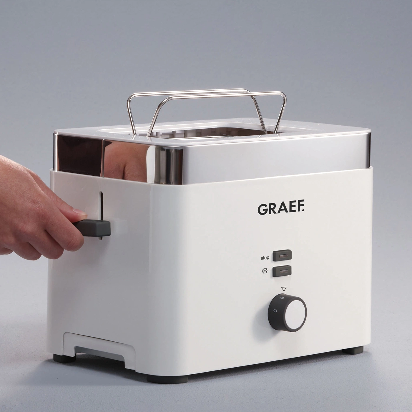 Weißer Toaster mit Bedienknöpfen und einem Handgriff aus Metall, GRAEF-Logo.