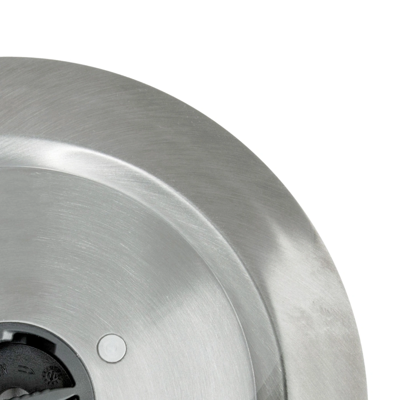 Close-up of a silver metal plate with a white circle in the center