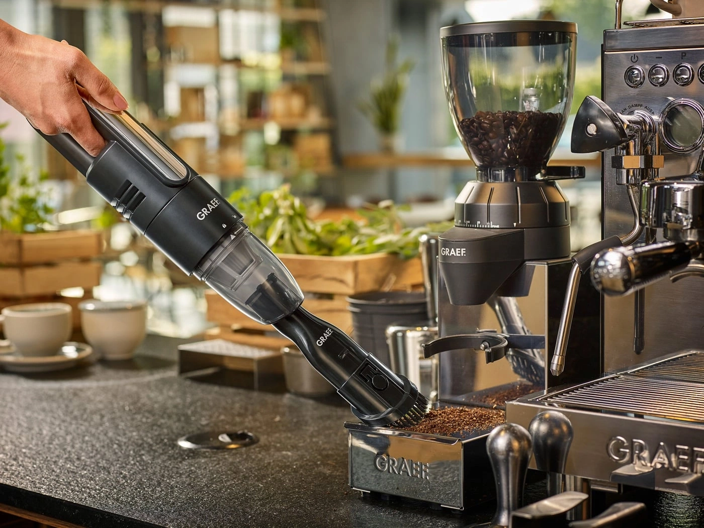 Coffee machine with vacuum cleaner. Cleaning coffee grounds. GRAEF brand. Black vacuum cleaner.