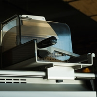 Nahaufnahme einer Fleischschneidemaschine mit Schutzvorrichtung und Griff