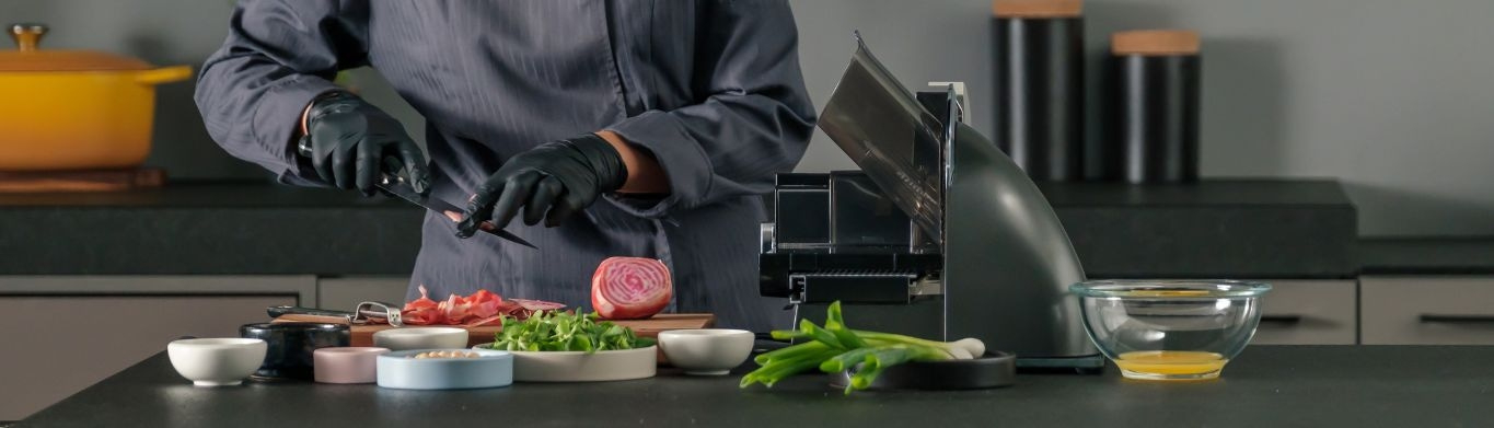 Koch bereitet Essen zu, Gemüse und Zutaten auf dem Tisch, Messer und Schneidemaschine