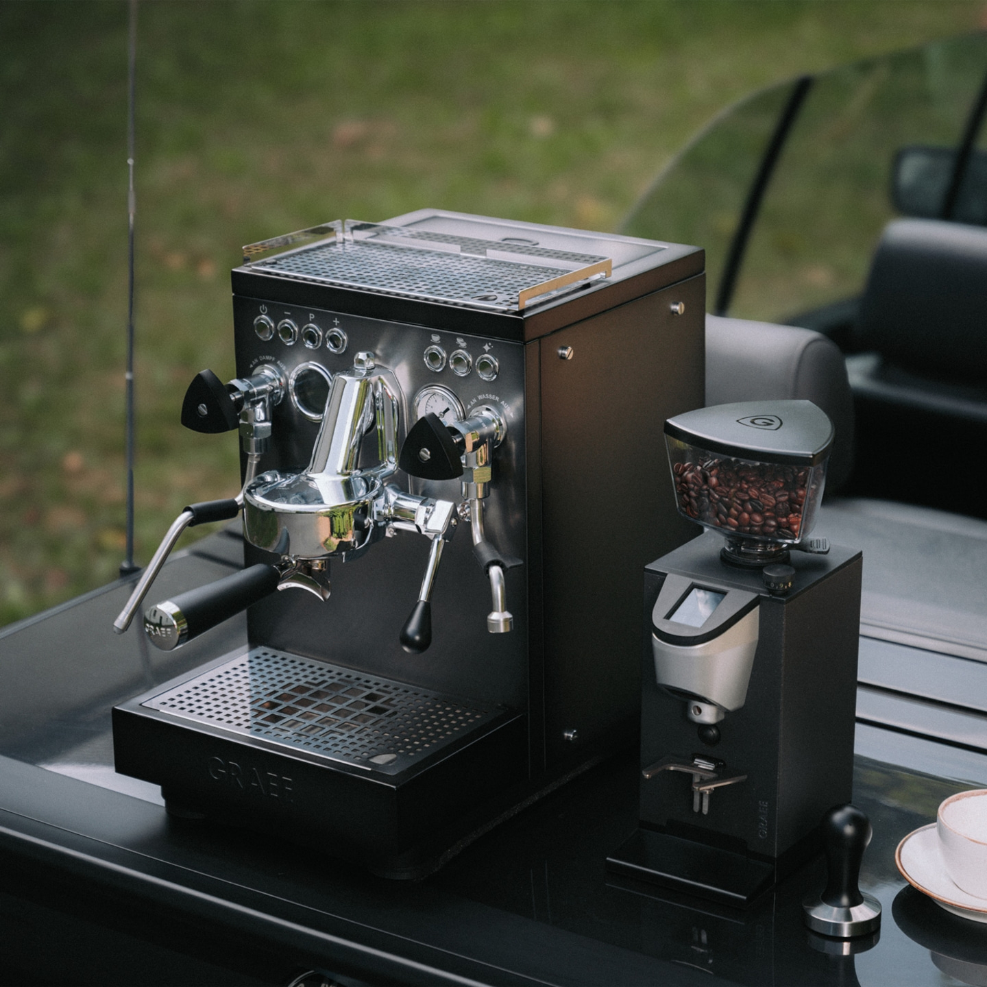 Graef espresso machine and coffee grinder outdoors on a table.