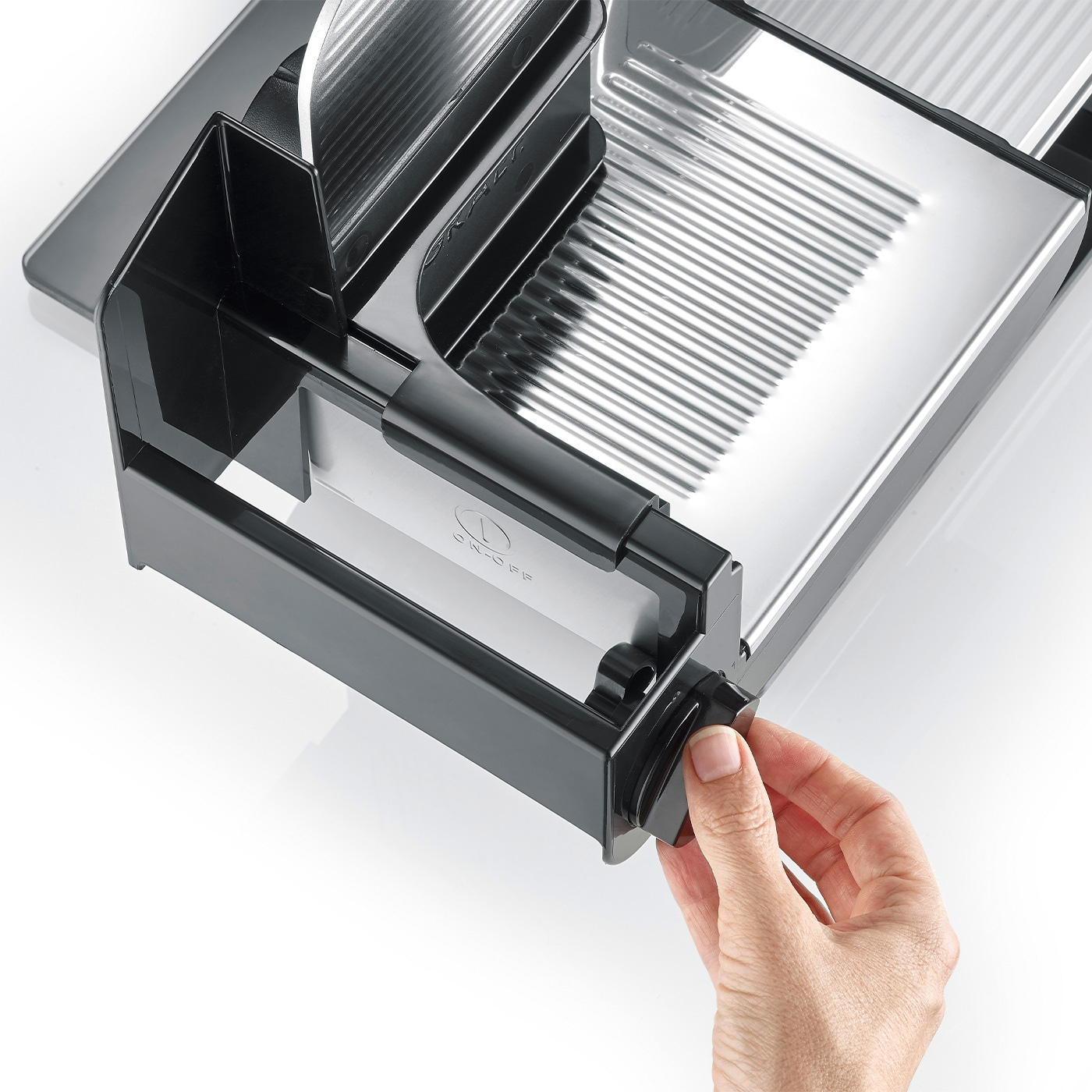 Nahaufnahme eines schwarzen Fleischschneiders mit einer Hand, die einen Knopf dreht