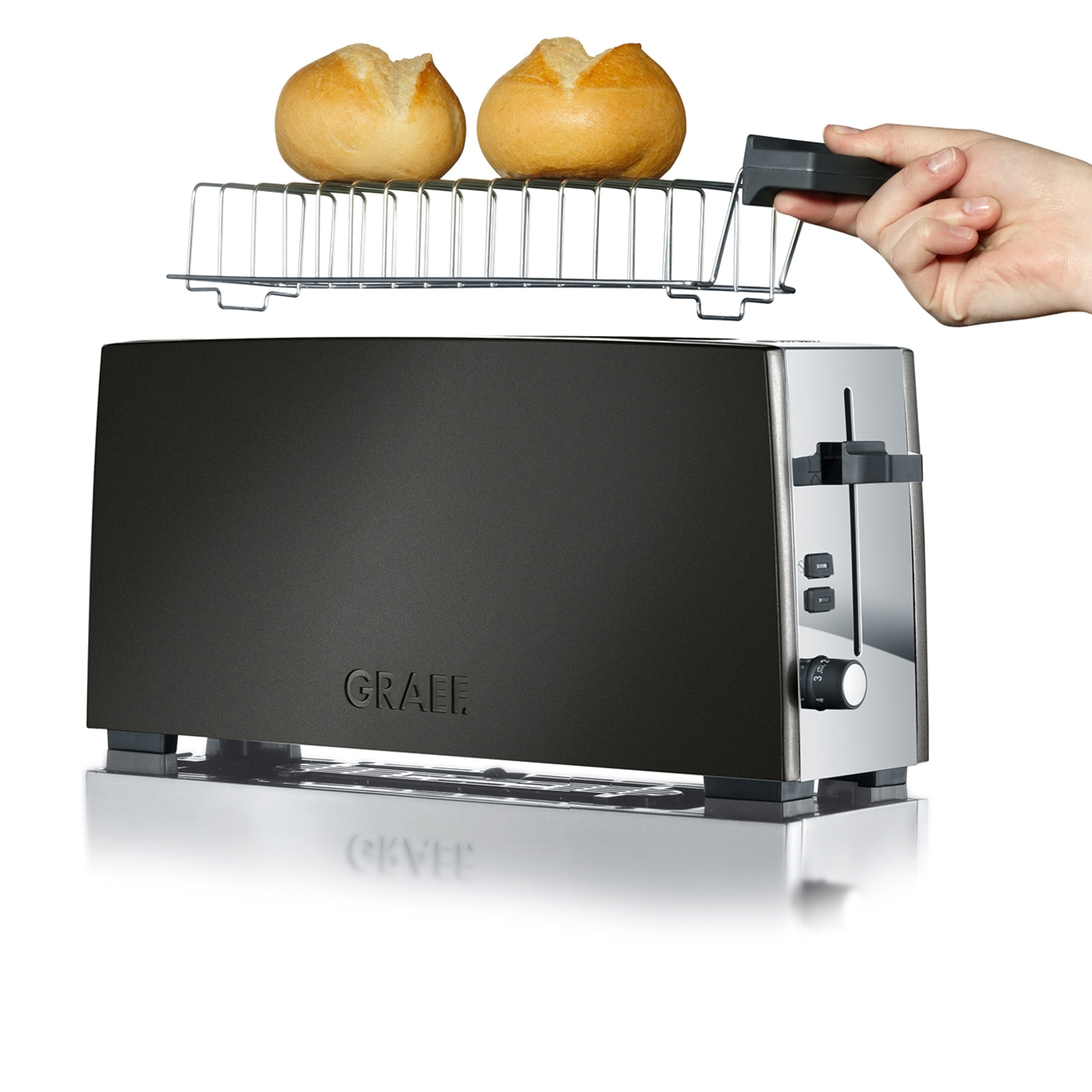 Toaster mit Brötchenaufsatz und zwei Brötchen, Hand hält Griff