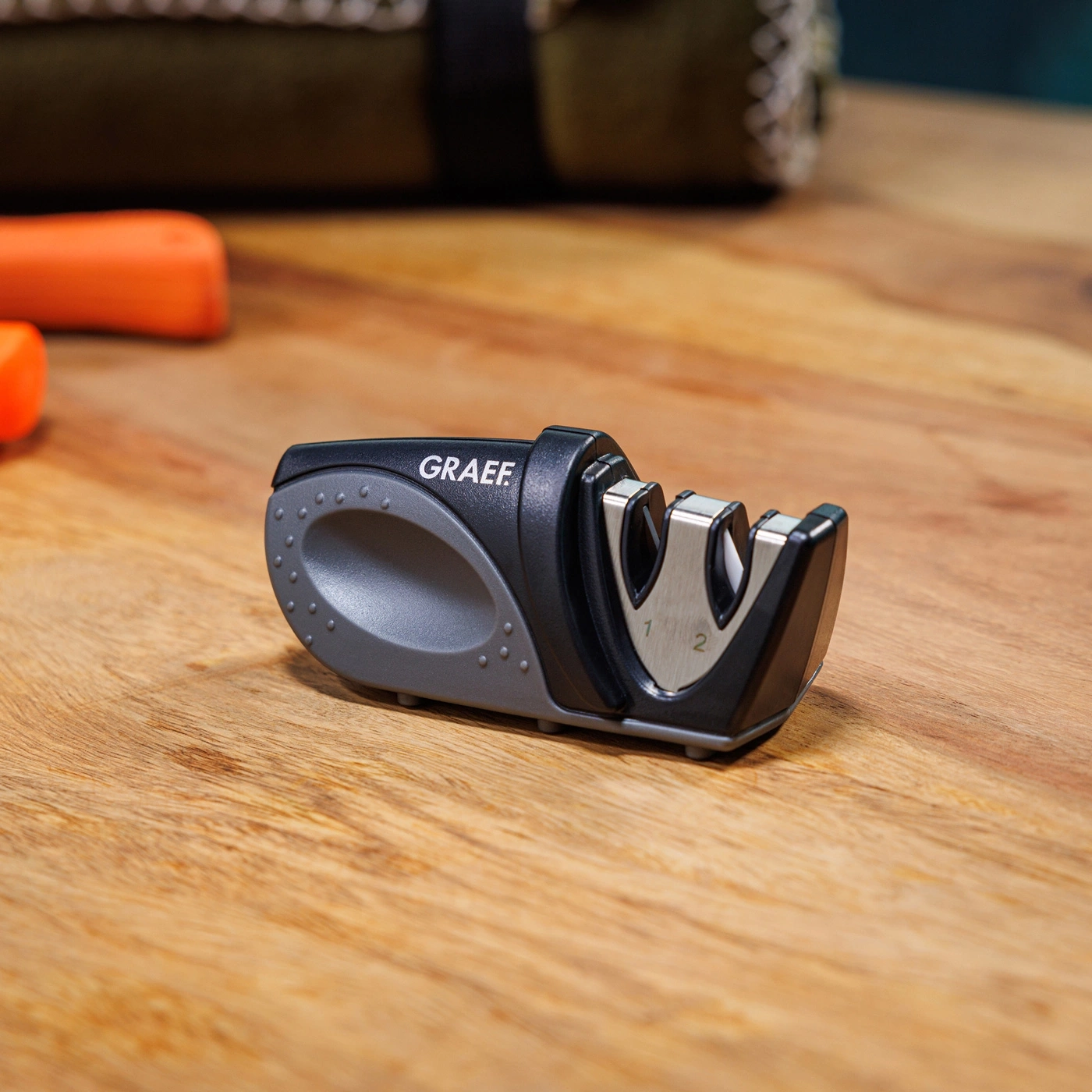 Graef knife sharpener on wooden surface with carrots in the background