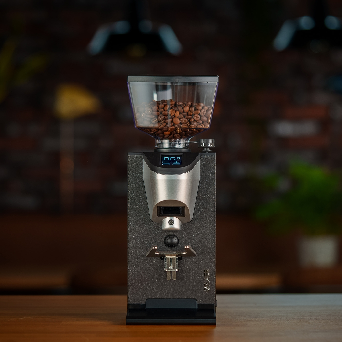 Coffee grinder with bean hopper on wooden table, digital display screen