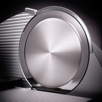 Close-up of a silver meat slicer with a shiny surface and intricate details