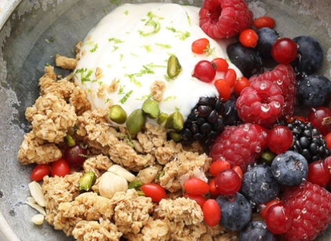 Müsli mit Joghurt, Beeren und Pistazien in einer Schüssel