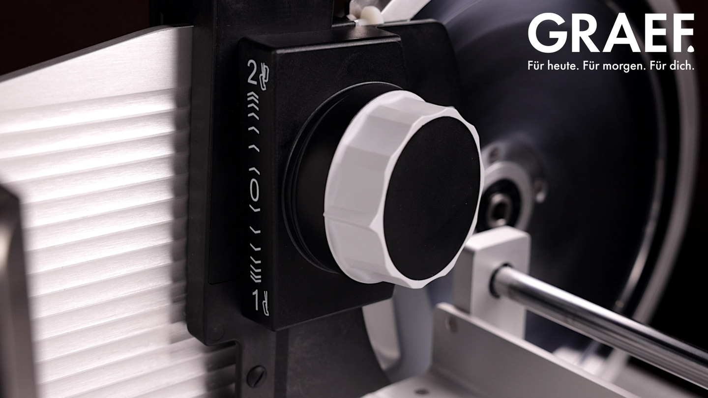 Nahaufnahme einer GRAEF-Schneidemaschine mit Einstellrad und Logo, Text: Für heute. Für morgen. Für dich.