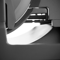 Abstrakte Nahaufnahme von grauen Metallstrukturen mit Licht und Schatten.