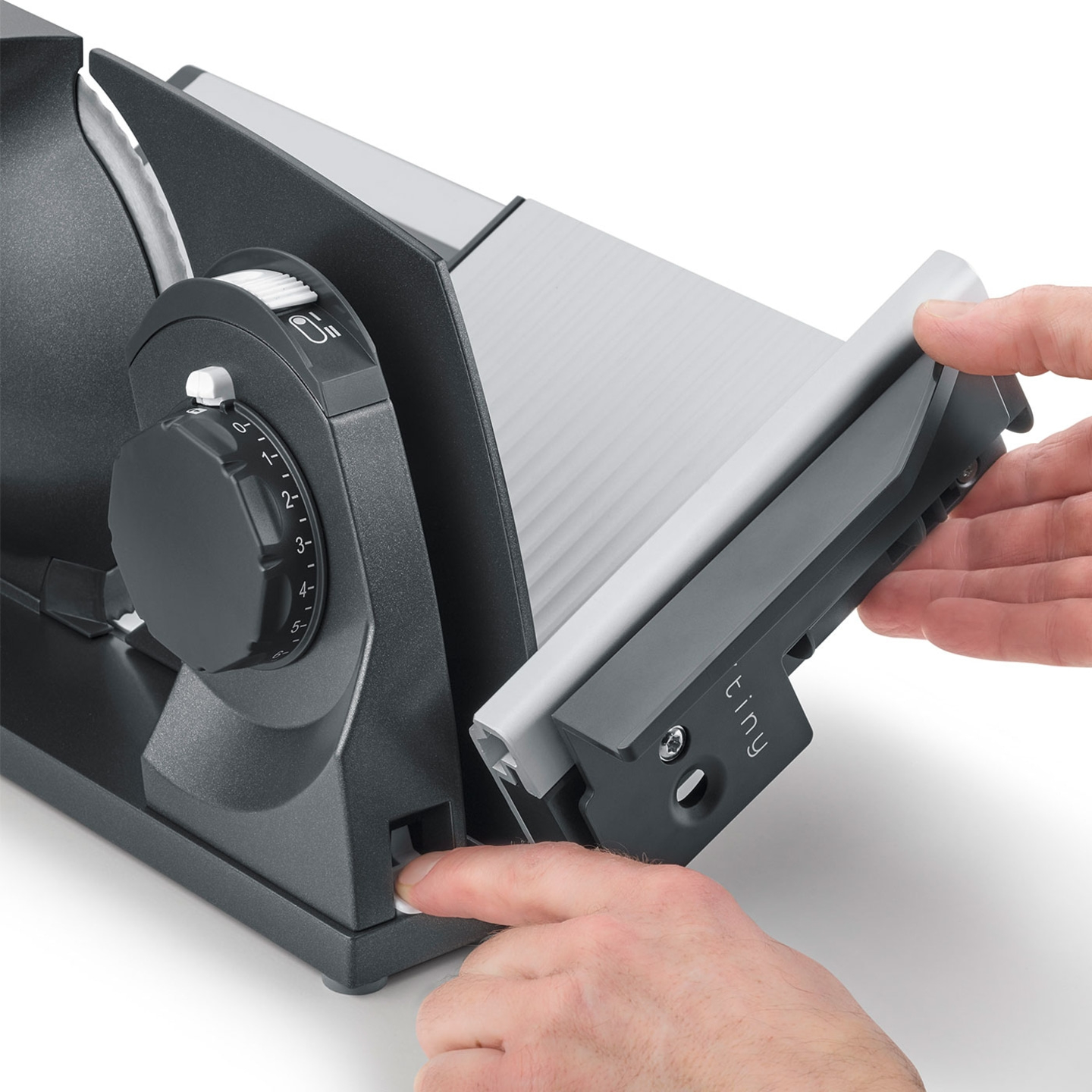 Nahaufnahme eines elektrischen Fleischschneiders mit Bedienelementen und Händen