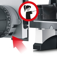 Sicherheitszeichen auf einer Schneidemaschine mit rotem Pfeil und Frauensymbol
