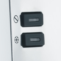 Zwei schwarze Knöpfe mit Symbolen, die auf einer weißen Oberfläche angebracht sind.