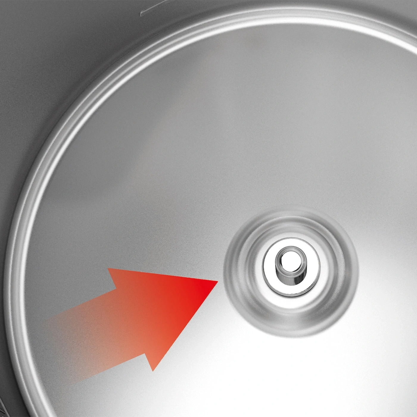 Red arrow pointing to a silver, round object with a hole in the center.