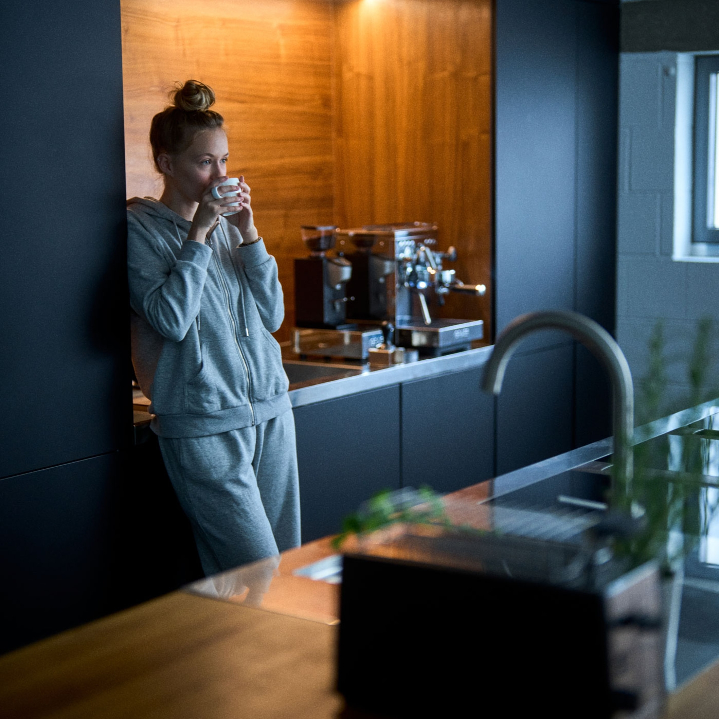 Frau trinkt Kaffee in der Küche, entspannt und gemütlich am Morgen.