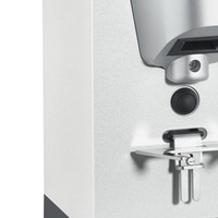 Close-up of a silver appliance with a button and metal components.