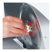 Hand dreht an einem Rad mit rotem Pfeil, um ein Objekt zu befestigen.