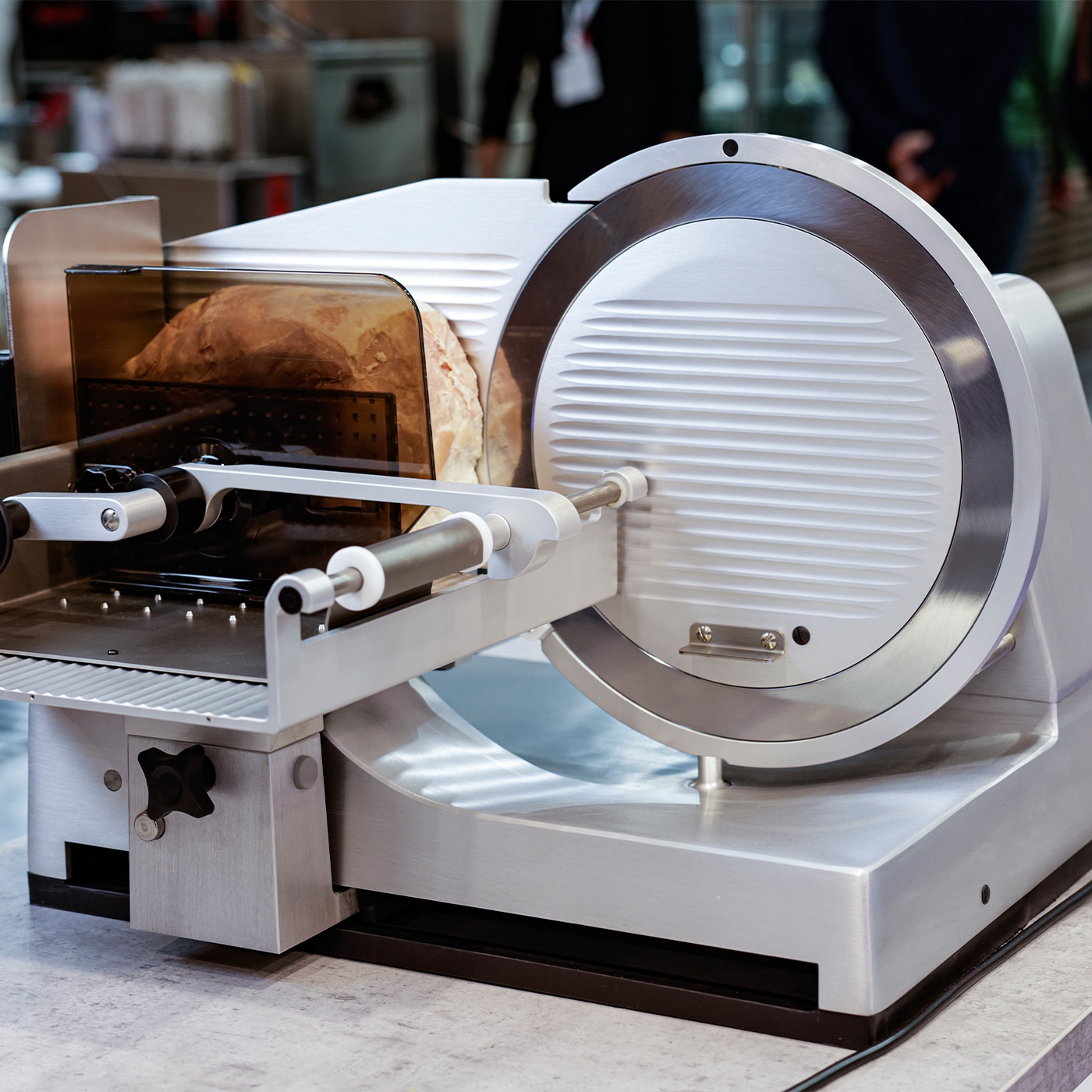 Fleischschneidemaschine mit Brot. Edelstahl, professionell, Küche, Lebensmittel.