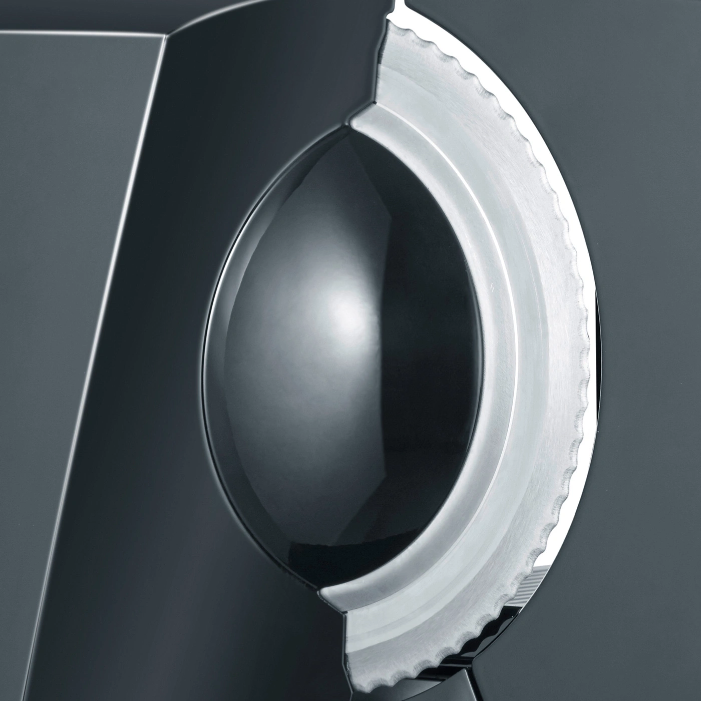 Close-up of a sharp blade and a silver wheel on a dark background.