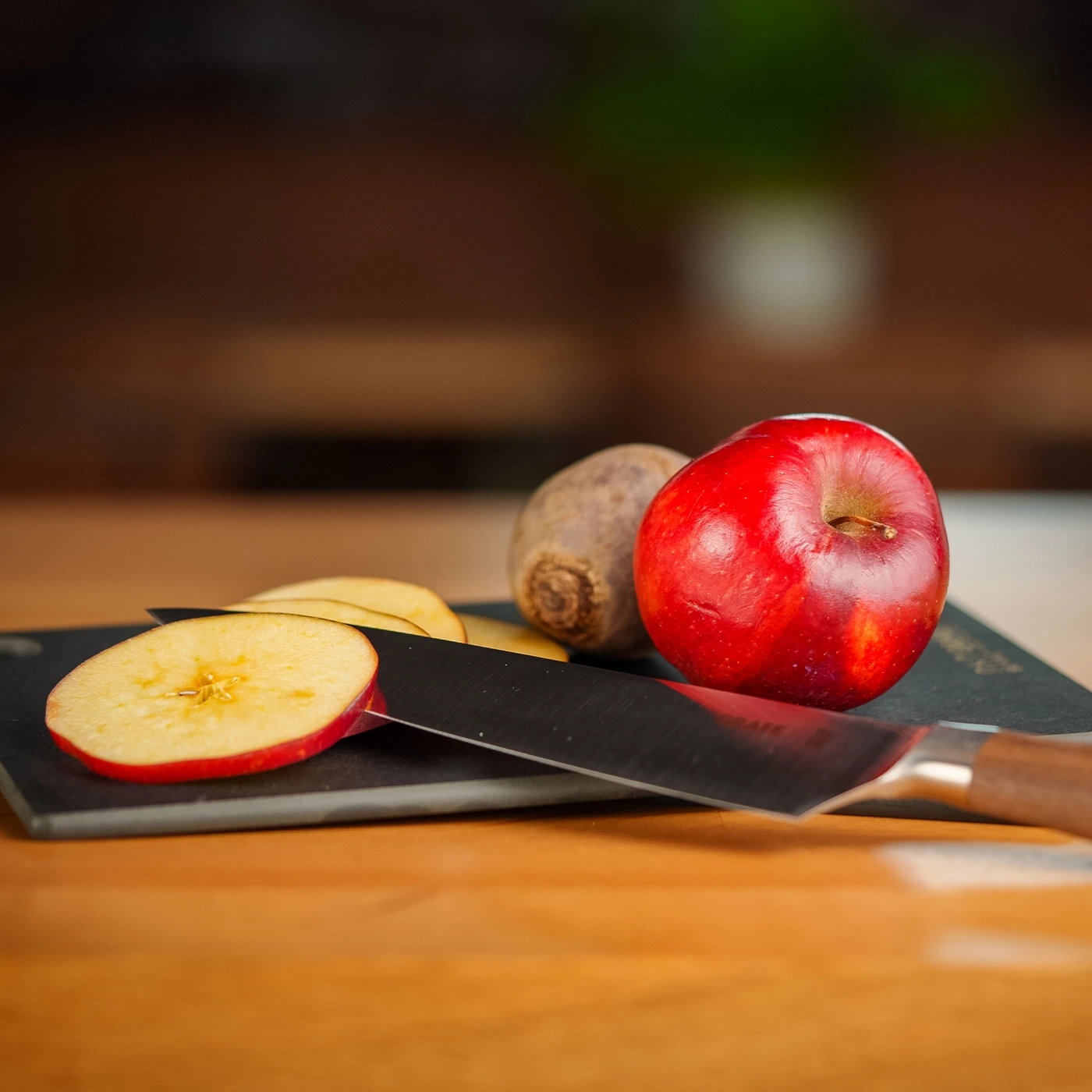 Apfel, Messer und Rüben auf einem Holzbrett. Nahaufnahme.