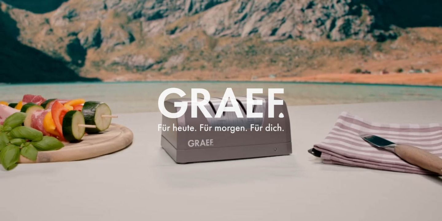 GRAEF-Werbung mit Essen, Messer und Landschaft im Hintergrund.