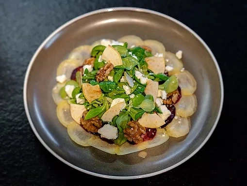 Salad with pear, walnut, cheese and greens on a plate