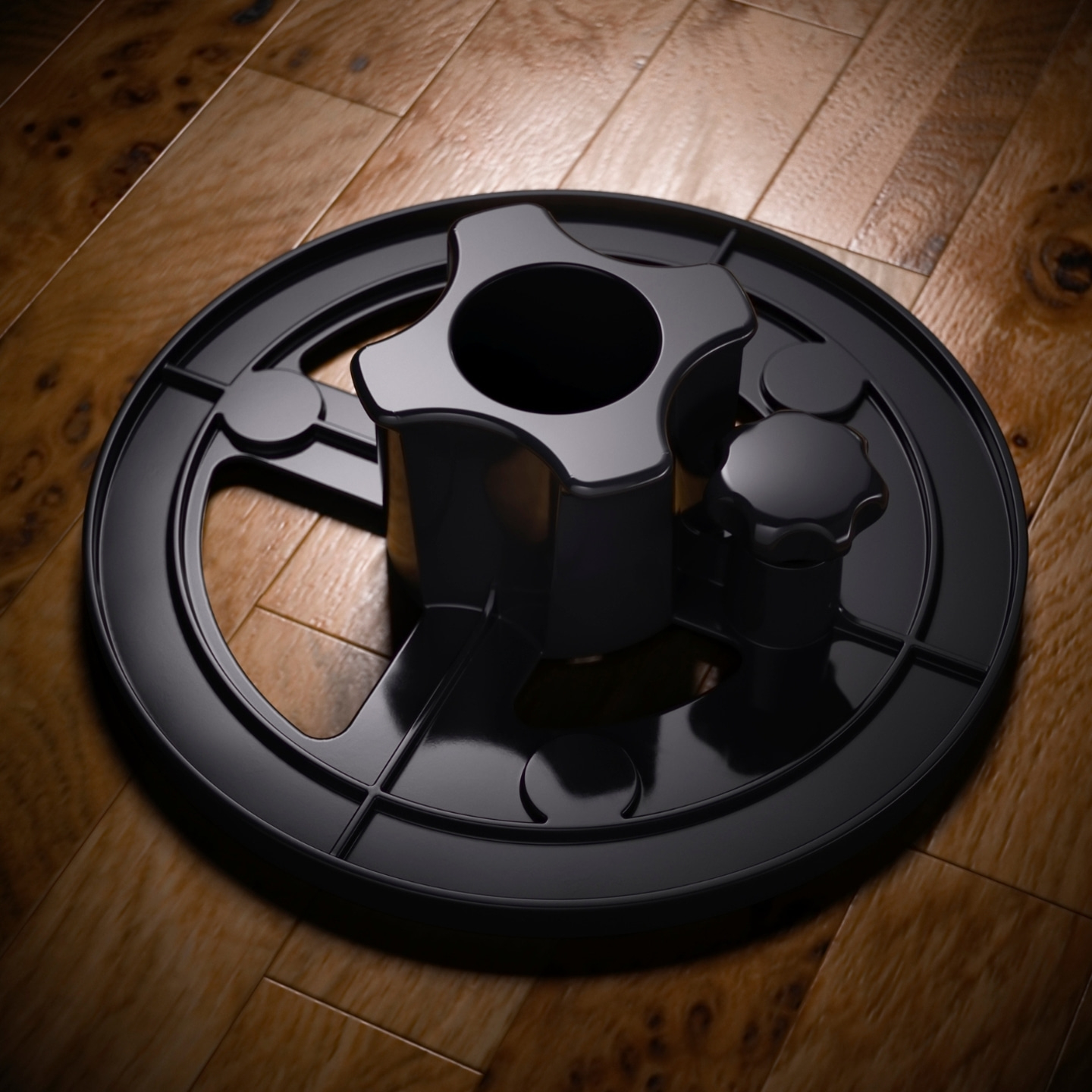 Black object on wood. Round base with knobs and a central hole. Shiny surface.