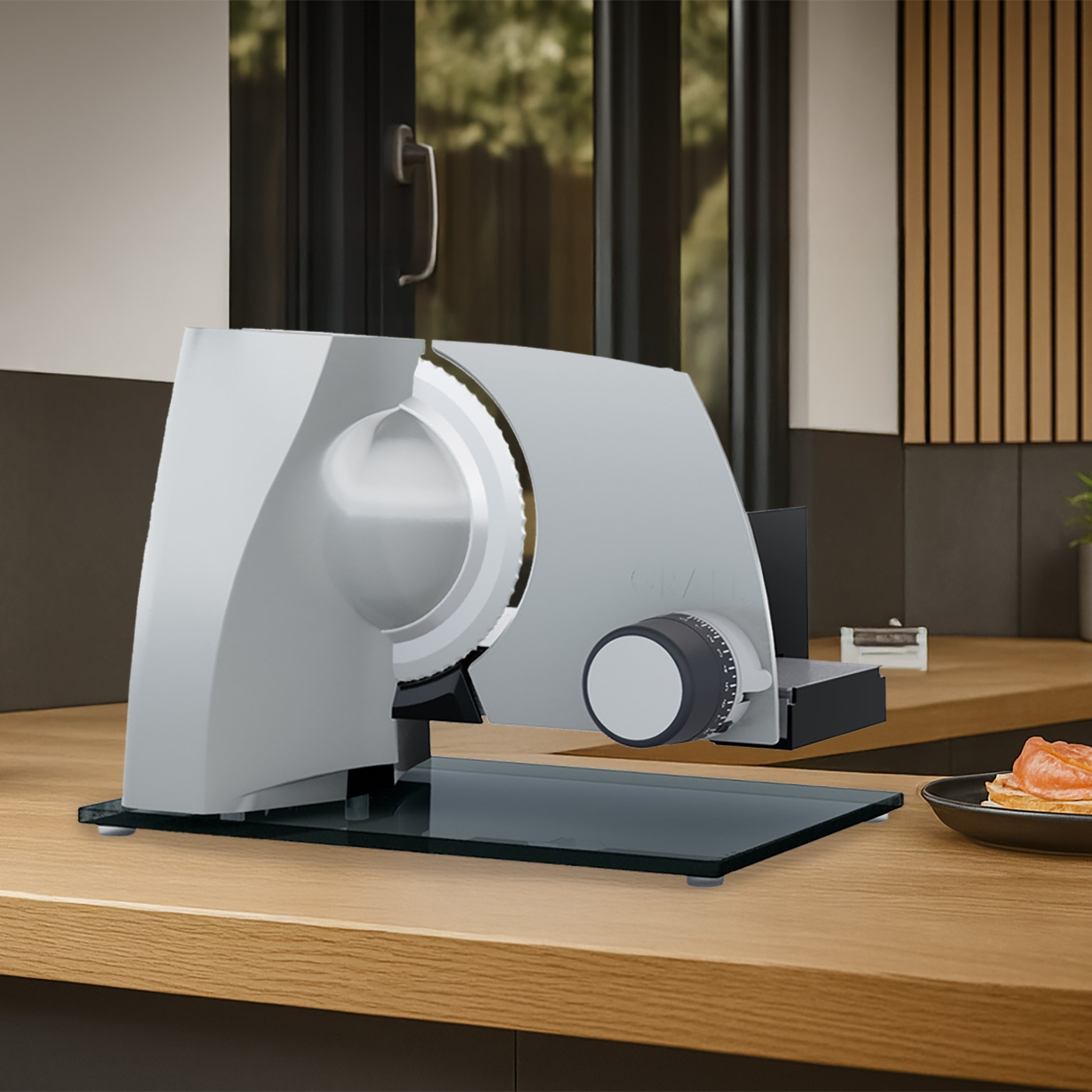 Grauer Fleischschneider auf Holztisch mit Essen im Hintergrund