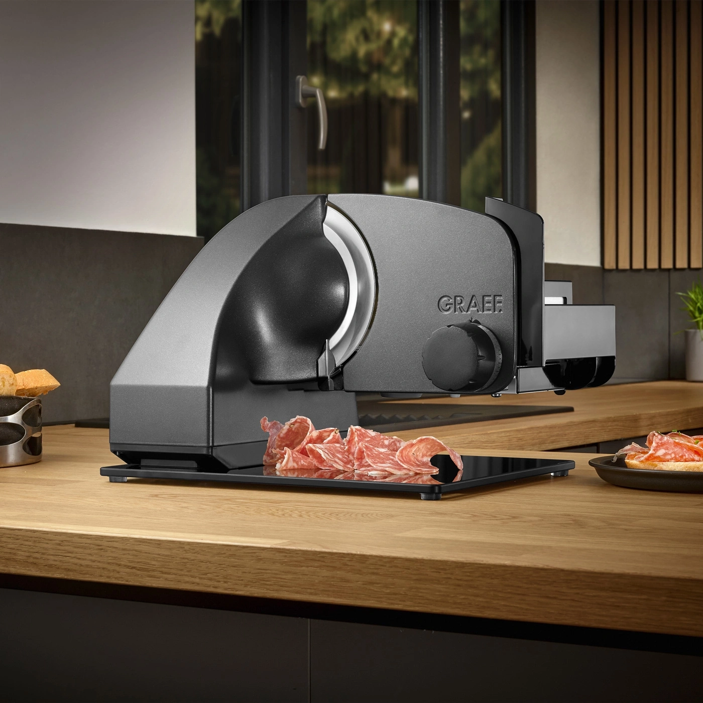 Graef slicer on wooden table with sliced meat and bread